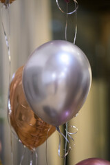 Close Up Of Shiny Metallic Balloons Floating Gently During A Celebration Event With Soft Bokeh Background Lights Illuminating The Festive Atmosphere
