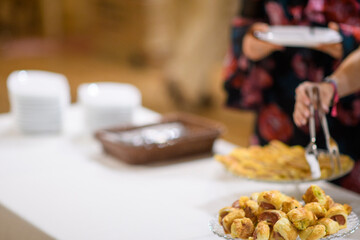 Delicious appetizer buffet spread with guests serving themselves small bites and pastries at a party event