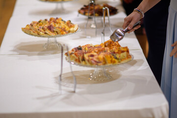 Gourmet appetizers presented elegantly on tiered glass stands at an event ready for guests to serve themselves delicious bites