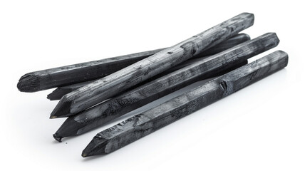 A small pile of rough, pointed vine charcoal sticks for drawing and sketching isolated on a white background.