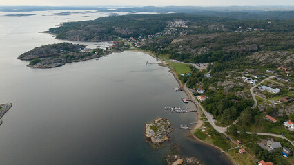 Aerial View of Coastal Village Near Str&ouml;mstad, Sweden with Rocky Hills, Waterfront Homes, Small Harbor, and Calm Sea on an Overcast Day