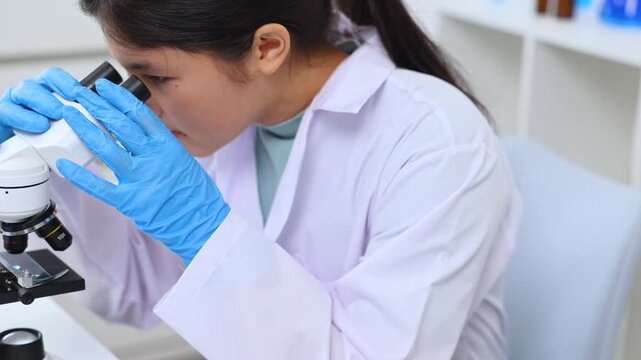 Teen girl observing a sample under the microscope during experiment. Science, laboratory, scientist, experiment, and research express hands-on learning and curiosity in a lab environment, healthcare.