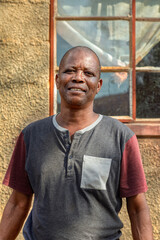 single african man portrait, in the village, standing in front of the house, rural life in Botswana,