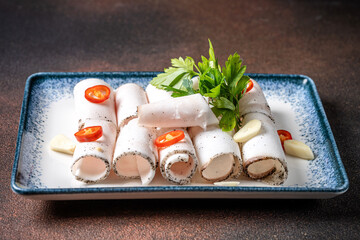 Rolled pork fat with garlic and chili on plate