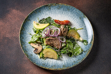 Top view of warm beef salad with avocado and mushrooms