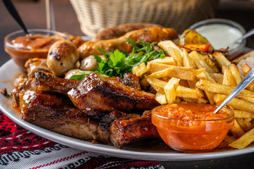 Grilled meat platter with fries and sauces
