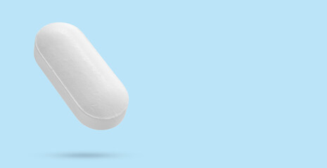 White medicine pill tablet float on blue background