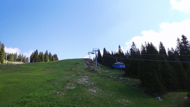 Drone flying over chairlift in summer, near Forte Verena, Italian Alps, Italy. Slow tilting aerial