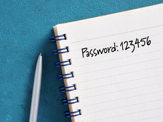 Weak password written on notebook with pen on blue desk