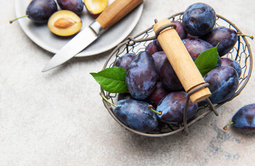 Fresh plums in basket with sliced fruit