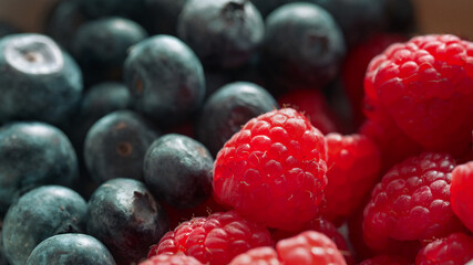 Close-up macro shot of fresh raspberries and blueberries showing natural texture and vibrant colors