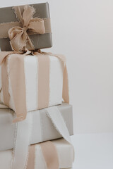 Gift boxes stack over white wall. Festive Christmas, New Year holidays celebration concept with blank mockup copy space