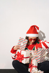 Woman in holiday costume holding multiple wrapped Christmas gift boxes cheerfully