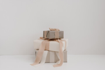 Christmas, New Year composition. Stack of handmade winter holidays gift boxes with bows and ribbons. Festive packaging concept
