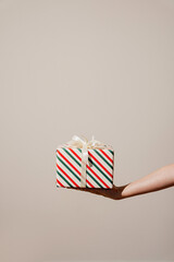 Striped Christmas Gift Box with Ribbon on Hand