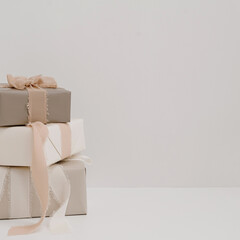 Gift boxes stack over white wall. Festive Christmas, New Year holidays celebration concept
