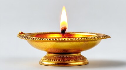 Golden diya lamp glowing with bright flame isolated on white background, symbol of diwali festival