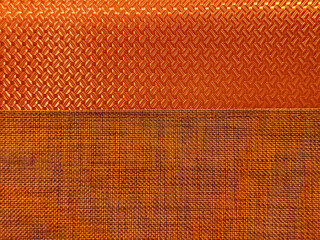 Close up of synthetic leather and fabric in random denim linen and weaving checker plate pattern, in orange and copper metallic color. Suitable for wall covering and upholstery. Seamless background 