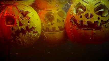 autumn holiday Halloween 2025 scary orange pumpkins drowning in water with bubbles and splatters in blood red light in the dark - Powered by Adobe