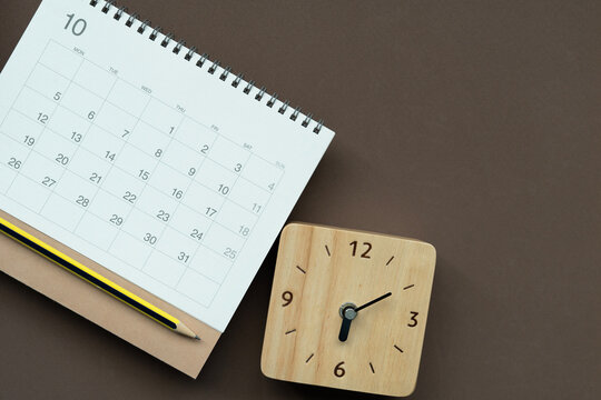 close up of calendar and clock on the brown table background, planning for business meeting or travel planning concept