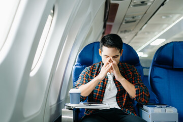 Travel stress, jet lag, or motion sickness. Young man with a headache or fatigue during a long...