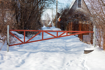 A red metal gate is in the snow