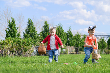 Obraz premium Kids Hunting Easter Eggs Outdoors on Sunny Spring Day