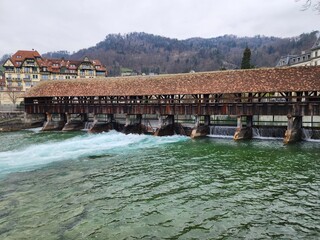 The Scherzligschleuse, or Obere Schleuse covered bridge, in Thun, Switzerland, serves as a sluice gate to control the flow of the Aare River. The bridge connects the town to the island of Balliz