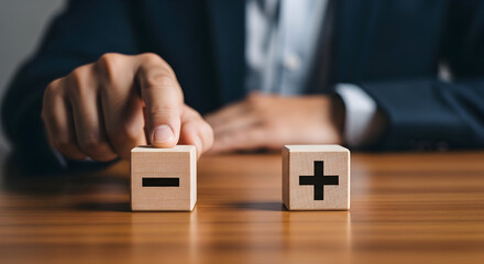 Businessman weighing pros and cons with plus and minus blocks on desk