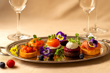 Refined gourmet canapés on silver platter soft golden light, elegant table setting, edible flowers and berries.