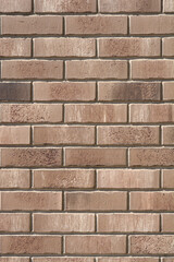 A full-frame close-up shows a stretcher bond brick wall composed of long, rough brown and tan bricks with recessed mortar joints