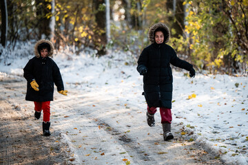 Fototapeta premium Children running in snow on forest path