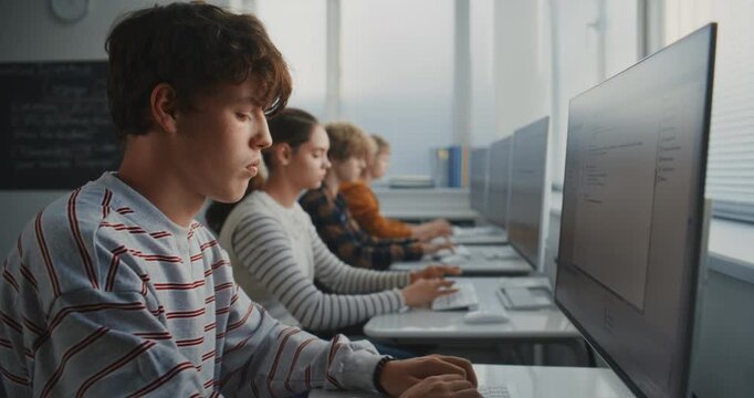 Close Up of Student in Striped Shirt Concentrating on Writing Code. Computer Lab With Classmates Working on Game Design Projects. Concept of Modern Education and Future IT Skills. Static Shot.