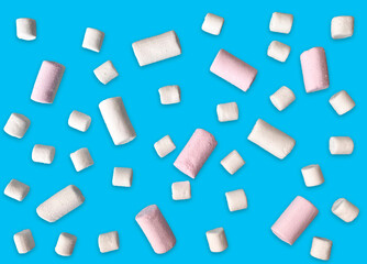 White and pink marshmallows scattered on a blue background.