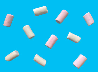 White and pink marshmallows scattered on a blue background.