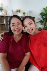 Mother and daughter smiling together in a cozy indoor setting