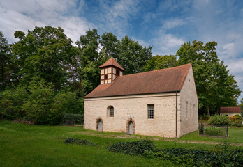 Obraz premium Blick von Südosten auf die denkmalgeschützte Dorfkirche Dahmsdorf am 66-Seen-Wanderweg mit Fachwerkturm und zwei Feldsteinportalen