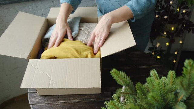 Christmas donation, charity concept. Woman contributes items for Christmas charitable donation