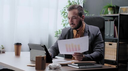 Young businessman analyzing financial report chart in office - Powered by Adobe