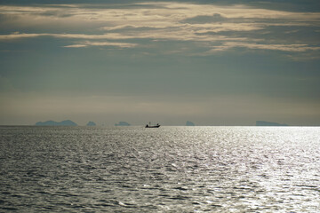 Panoramic sunset beach landscape in Thailand. Sunset sky calmness tranquil relaxing sunlight summer mood. Silhouette of fishing boat at sunset over the sea