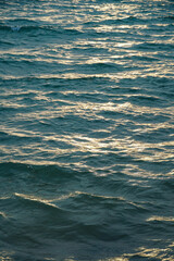 Water ripple surface texture, Rippling water surface with sunset reflection ripples. Golden sunset on rippling ocean waves. Tranquil water ripples reflecting sunlight.