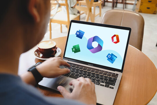 Bangkok, Thailand. October 13, 2025; A person using the Microsoft 365 suite on a laptop, with logos for Word, Excel, PowerPoint, and Outlook on screen.