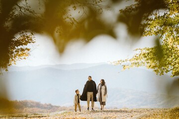 Family walking autumn outdoor, expecting new baby