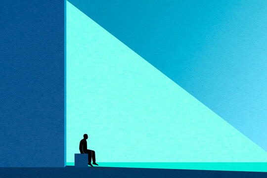 Man sitting alone indoors with blue abstract background and copy space