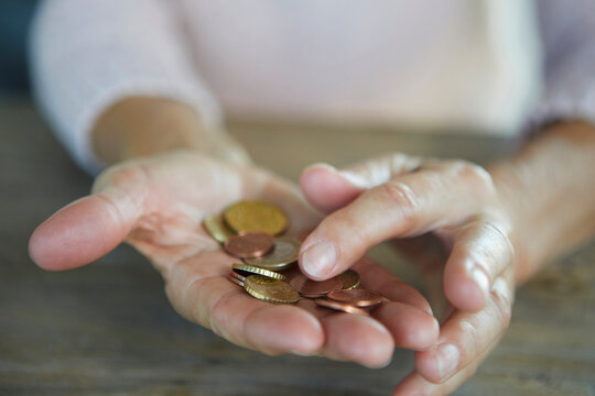 Hand holding coins representing poverty and financial hardship