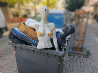 Damage plastic fashion figurines in the trash container