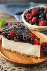 Piece of delicious cheesecake with berries on wooden table, closeup