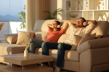 Happy couple with headphones listening music and relaxing