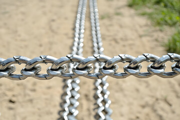 Gleaming silver chains stretch across a sandy landscape, disappe