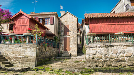 Casas de piedra y tradicionales hórreos gallegos pintados de rojo en la villa de Combarro, España © David Andres